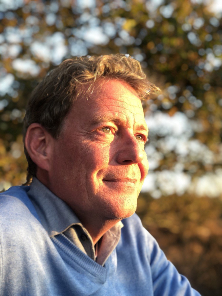 About me. Rik Schelfhorst, your Healer for Pranic Healing, staring at the setting sun, soft light emphasizing his calm and reflective demeanor, symbolizing his journey from the pharmaceutical industry to energetic healing.